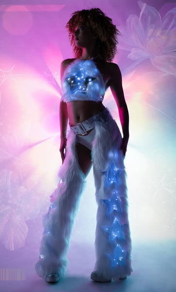 Person wearing a futuristic Faux Fur Chaps outfit with glowing blue light stars against a colorful abstract background